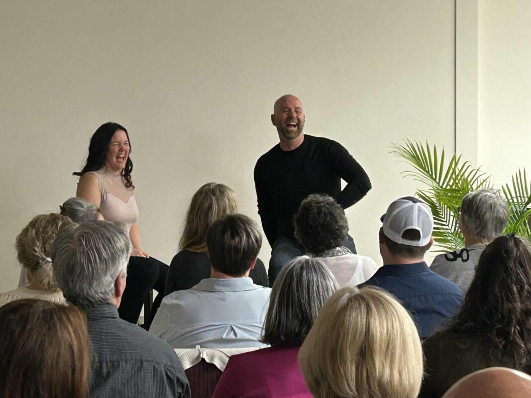 Evelyne Desrochers et François Lemay riant ensemble devant un public.